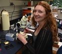 Researcher Summer Praetorius with a microscope in a lab
