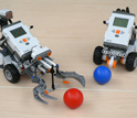 Photo of robots programmed by students that are handling balls.