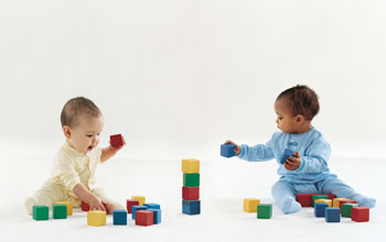 Photo of two babies playing with blocks.