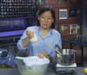 Photo of Julie Yu making fresh cheese from milk and lemon juice.