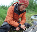 Female gradute student examines lake sediment core from southern Alaska