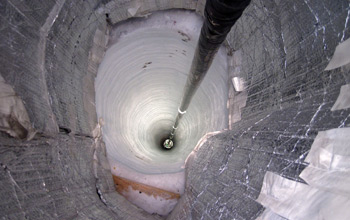 Photo of a sensor descending down a hole in the ice as part of the final season of IceCube.