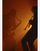 Photo of men playing a saxaphone and a trumpet.