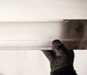 Photo of gloved hands holding an ice core sample with black layers containing bits of rock.