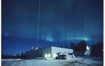 Photo of the aurora and a laser radar beam lighting up the sky at the Lidar Research Laboratory.