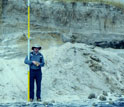Scientist with measuring stick checks vertical erosion at the Cupsogue Beach, N.Y.