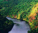 Photo of a river crossing forested hills.