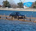 Photo of a car crossing a nearly submerged causeway along the New Hampshire coast.
