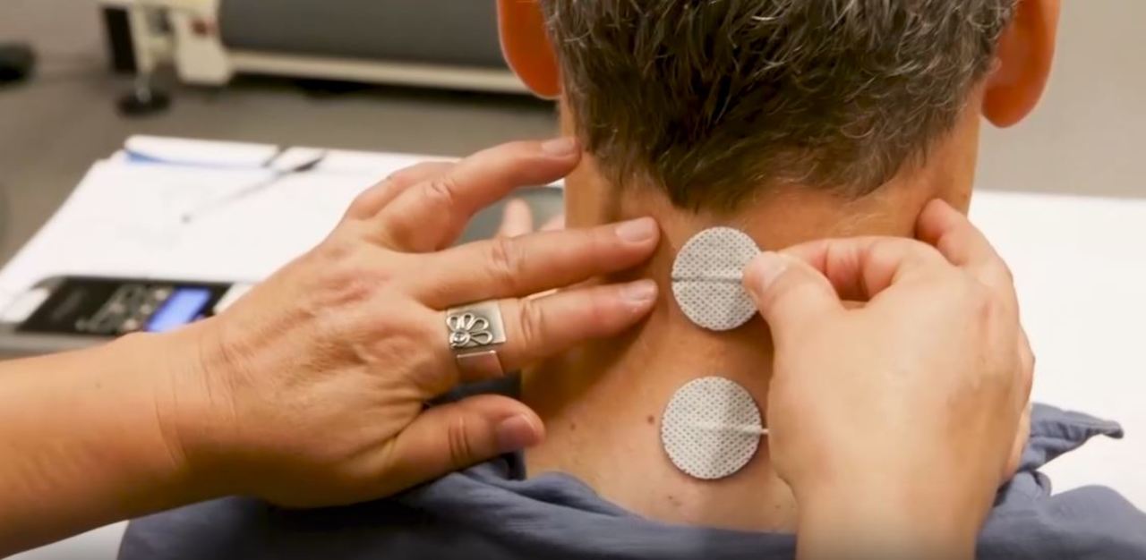 a person with sensors attached to the back of their neck