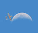 Photo of  AUAV involved in the Maldives project flying by the moon in a blue sky.