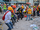 volunteers remove debris from a collapsed building