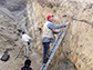 Professor Steve Wesnousky examines layers of rock and soil in a trench in Tribeni